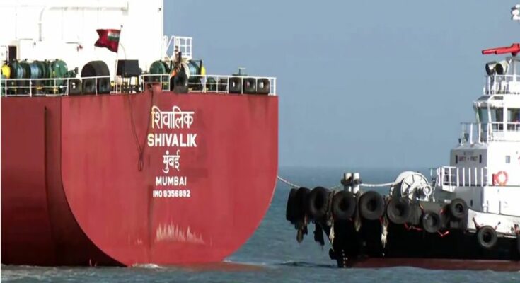 A conceptual geopolitical image showing the flags of India and Iran alongside a commercial oil tanker traversing the Strait of Hormuz during the ongoing crisis.
