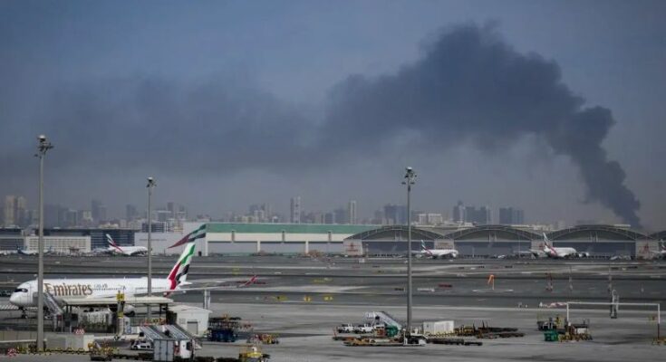 Security forces and emergency vehicles at Dubai International Airport responding to the aftermath of a suspected Iranian drone attack.