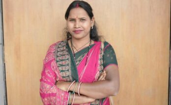 A confident rural Indian woman smiling while working at her own small shop, representing financial independence achieved through the Mahtari Vandan Yojana in Chhattisgarh.