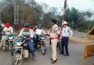 Traffic police personnel issuing an e-challan to a vehicle owner for using a fancy and defective number plate during a strict road safety drive.