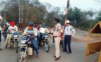 Traffic police personnel issuing an e-challan to a vehicle owner for using a fancy and defective number plate during a strict road safety drive.