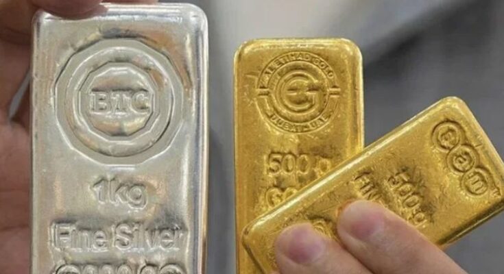 A digital display showing drastically falling prices of gold and silver representing a market bloodbath.