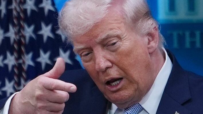 A conceptual image highlighting the Donald Trump Tariff, showing the 47th US President Donald Trump issuing a warning, with cargo ships, weapons, and a 50 percent tax sign in the background.