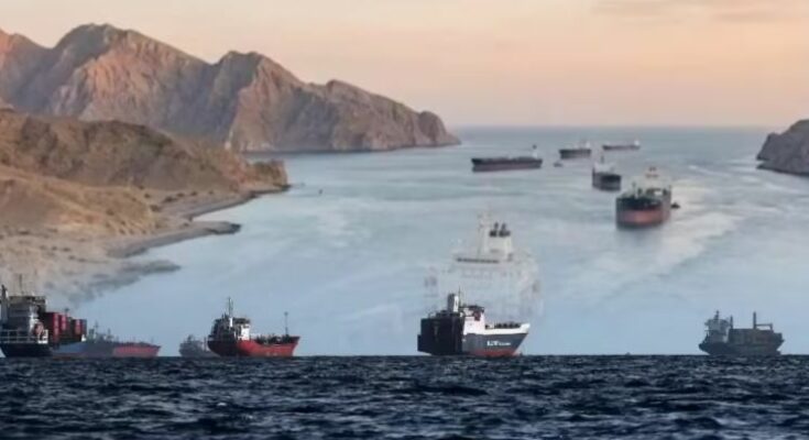 होर्मुज स्ट्रेट से गुजरता हुआ एक विशाल कार्गो शिप और नीचे गिरते हुए कच्चे तेल के दामों का लाल ग्राफ