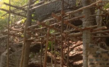 A conceptual image highlighting the Kanger Valley Green Cave controversy, showing a beautiful natural cave with green stalactites overshadowed by warning signs and cement construction.
