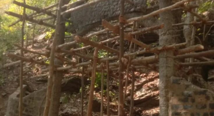 A conceptual image highlighting the Kanger Valley Green Cave controversy, showing a beautiful natural cave with green stalactites overshadowed by warning signs and cement construction.