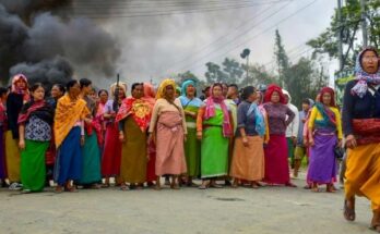 A conceptual image highlighting the Manipur Violence Updates, showing heavily armed CRPF personnel patrolling a smoke-filled street in Bishnupur, with a crossed-out Wi-Fi symbol representing the internet suspension.