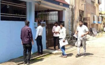 A conceptual image showing a census worker noting details digitally on a tablet outside a house with a fresh census number painted on the wall, highlighting the Raipur Census 2026.