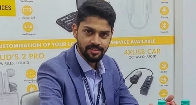 A conceptual image highlighting the Urban Success Story, showing founder Aashish Kumbhat holding a smartwatch with a background of business growth charts and gadgets.